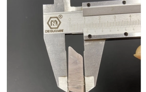Measuring the 10mm width of a natural rose quartz crystal hair stick with a caliper