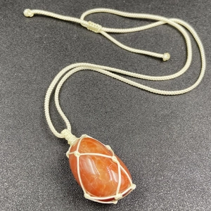 Handcrafted woven net necklace featuring a raw polished red agate stone pendant