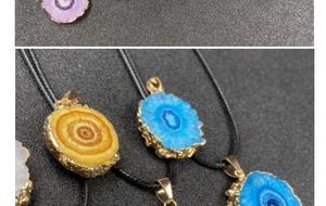 Detail of colorful crystal sunburst pendants with gold plated edges and black cords