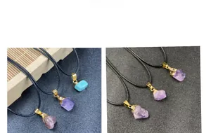 Detailed view of natural amethyst and turquoise raw stone pendants with gold metal fittings