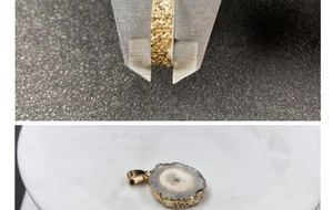 Detail showing caliper measurement of gold-plated edge thickness on colorful sunflower pendant