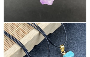 Detailed view of raw amethyst and turquoise pendants with golden bail and black cord