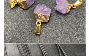 Macro detail of raw amethyst stone pendant with gold plating and black cord necklace