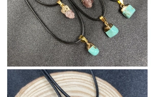 Detail of raw turquoise and rose quartz pendants on black cord necklaces with gold clasps