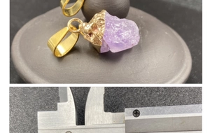 Macro shot of purple amethyst pendant with gold edge detailing and size measurement