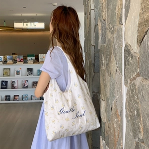 Borsa tote in tela floreale con ricamo Gentle Soul in un ambiente accogliente libreria