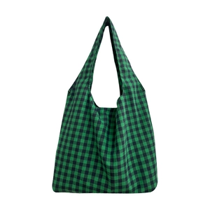 Green and black checkered canvas tote bag with wide shoulder strap on white background