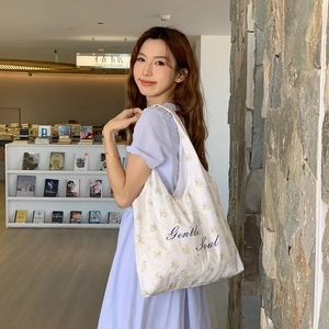Borsa tote floreale con ricamo Gentle Soul mostrata in una libreria accogliente