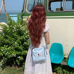 Détail du sac à bandoulière bleu clair avec cordon de serrage et broderie dalmatien