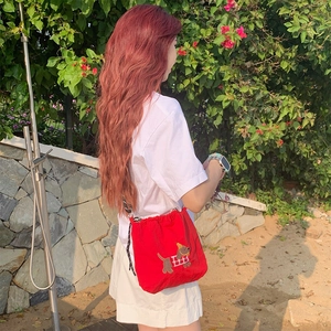 Détail du sac bandoulière en toile rouge avec broderie teckel et fermeture à cordon