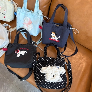 Detail of canvas mini bags with puppy embroidery and adjustable shoulder straps