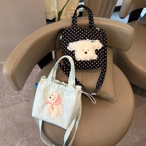 Detail view of cute canvas bags featuring embroidered puppy and bear designs for summer