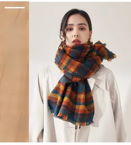 Detail of checkered cashmere scarf with vintage orange and navy pattern and fringe