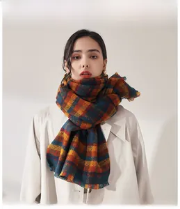 Detail of colorful plaid scarf with tassels on a trench coat in high-quality knit texture