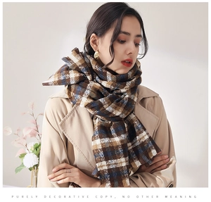 Close-up of thick plaid scarf with soft cashmere texture and elegant fringe detail