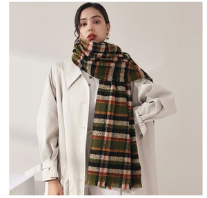 Close-up of thick green plaid scarf with soft cashmere-like texture and orange stripes