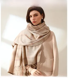 Close-up of the soft beige plaid scarf with fringe tassels for a stylish autumn look