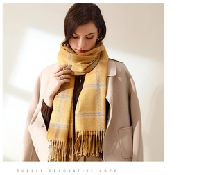 Detail of ginger yellow plaid scarf showing soft faux cashmere texture and fringe tassels