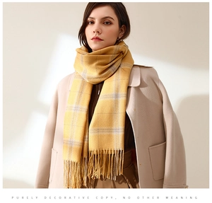 Detail of yellow plaid scarf with soft tassels paired with a beige wool winter coat
