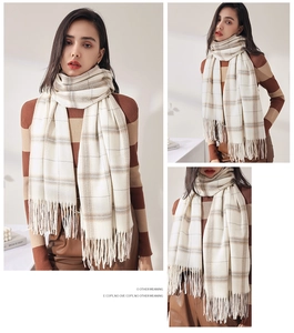Detail showing soft beige and brown plaid cashmere-feel scarf with delicate tassels
