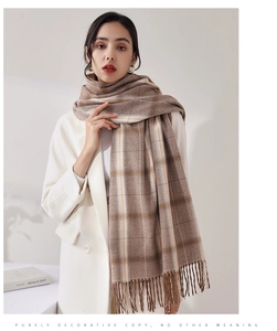 Detail of plaid tassel scarf in brown and yellow woven fabric worn with a white blazer