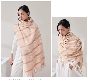 Detail of soft pink and beige plaid scarf showing knitted texture and long fringes