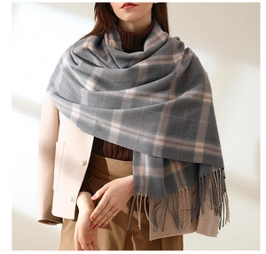 Detail of dark grey plaid scarf with soft fringe and thick cashmere-like texture