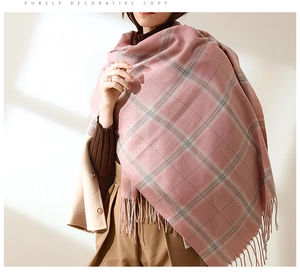 Close-up of pink plaid scarf texture featuring soft woven fringe and tassel details