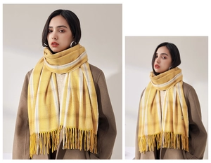 Close-up of yellow and white plaid scarf featuring thick knit texture and long tassels
