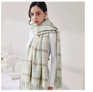 Detail of soft plaid scarf with tassels in light green and yellow checkered pattern