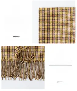 Détail d'une écharpe en maille à carreaux jaune gingembre avec de fines franges douces
