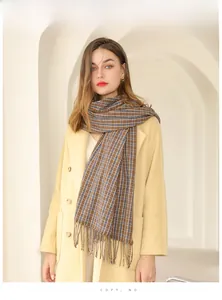 Détail d'une écharpe à carreaux marron et bleu avec franges sur un manteau