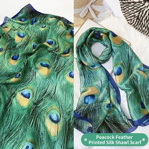 Peacock feather print silk scarf in emerald green and navy blue with smooth satin texture