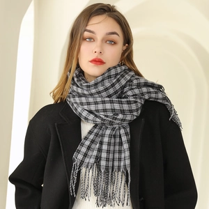 Écharpe classique à carreaux noir et blanc avec franges portée par un mannequin en intérieur