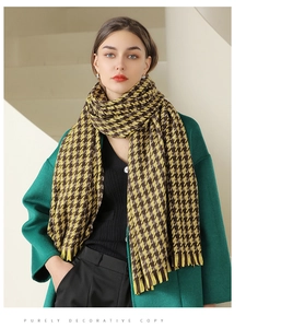 Detail of yellow and black houndstooth scarf with tassels on a wool coat outfit