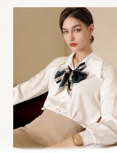 Detail of white silk blouse featuring a vintage polka dot ribbon tie with pearl buttons
