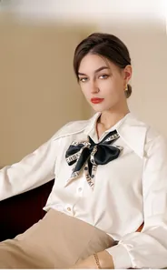 Detail of elegant white silk shirt featuring a vintage bow tie with HTKI letter print