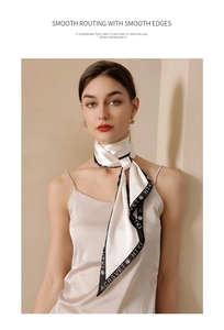 Detail of silk scarf with floral rose patterns and black borders styled on a model