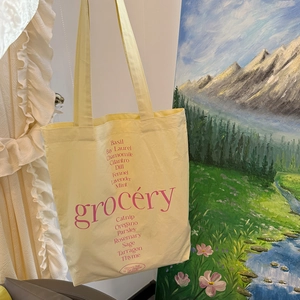 Bolso tote de lona amarillo claro con letras grocery rosas y nombres de hierbas