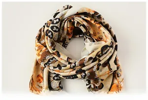 Detailed close-up of soft floral pattern silk scarf with elegant orange and brown tones