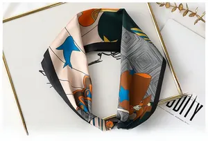 Détail d'un foulard en soie aux motifs abstraits géométriques dans un plateau doré chic