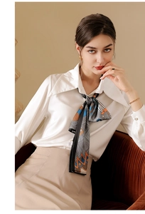 Détail d'un foulard en soie imprimé avec chemise en satin blanc et jupe beige chic