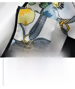 Macro detail of silky floral print ribbon scarf with blue leaves and yellow flowers