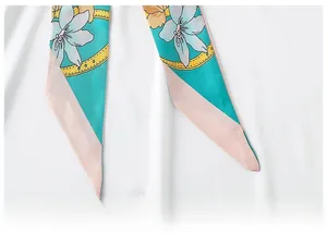 Detailed macro view showing flat edge stitching and floral satin fabric of the long scarf