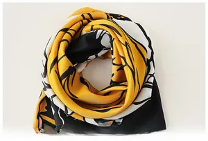 Macro detail of abstract floral printed silk-like scarf with yellow and black patterns
