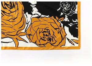 Detailed close-up of the fine edge stitching and vibrant rose floral print on the silk scarf