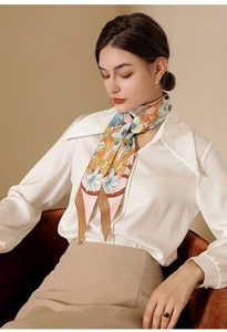 Elegant floral twilly scarf styled as a necktie knot on a silk blouse and skirt