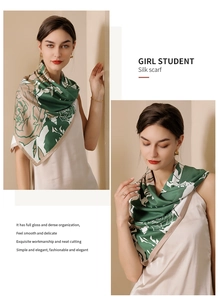 Detail view of floral print silk scarf with glossy texture on green and beige fabric
