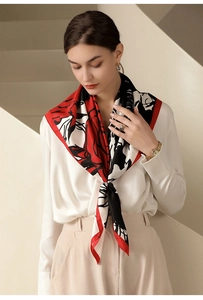 Elegant red floral silk scarf tied gracefully over a white shirt on a model
