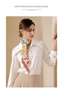 Close-up of floral silk scarf with smooth stitching details on white collared shirt